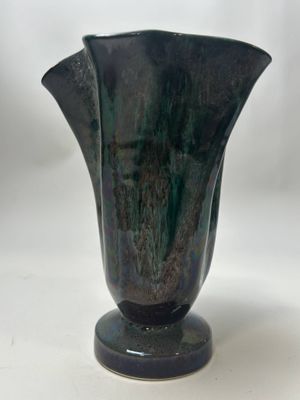 un vase noir posé sur une table blanche