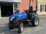 a blue tractor that is parked in front of a building