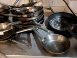 many pots and pans sitting on a shelf in the kitchen