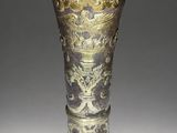 a silver and gold vase sitting on a table
