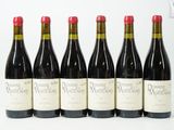 six bouteilles de vin rouge alignées sur une surface blanche