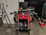 a red tool cart with a computer on top of it