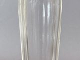 a small glass bottle with a silver lid on a table