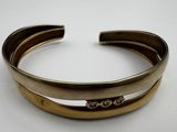 a close up of a gold cuff with a diamond on it
