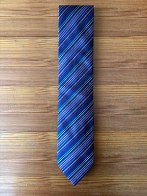 purple and blue striped neck tie on a wooden surface