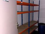 a room with shelves and a trash can in it