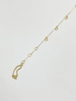 a close up of a gold necklace on a white background