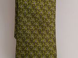 green and purple floral tie hanging on a white wall