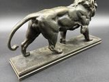 a bronze statue of a lion on a marble base
