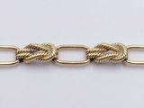a close up of a gold chain on a white surface