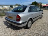 a silver car that is parked in the gravel