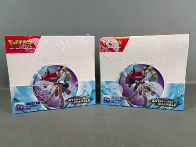 two boxes of pokemon trading cards are sitting on a table