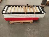 a red and white bed with wooden slats on it