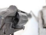 a close up of a gun on a white surface