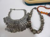 two necklaces and a bracelet sitting on top of a table