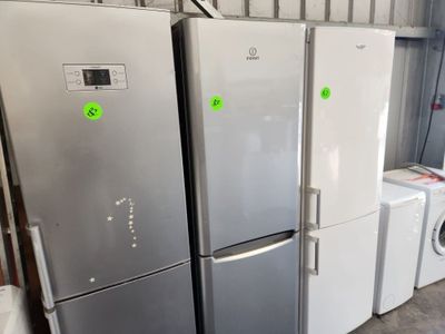 trois réfrigérateurs et une machine à laver dans une pièce