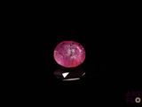 a close up of a pink diamond on a black surface