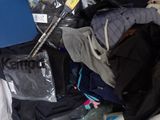 a pile of clothes and a laptop on a bed