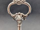 a close up of a silver spoon with a handle on a table