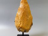 a close up of a piece of food on a stand on a white surface