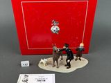 the figurine is sitting on the table next to the red box