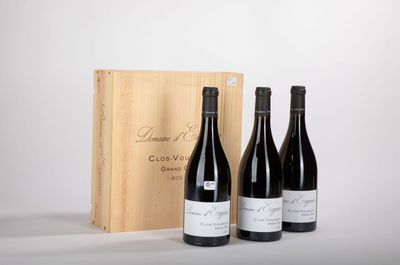 trois bouteilles de vin devant une caisse en bois