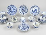 many blue and white plates and cups and saucers