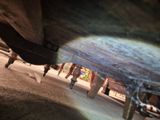 a close up of a person walking under a car