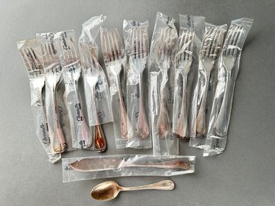 a lot of forks and spoons wrapped in plastic bags