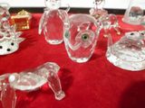 de nombreuses figurines en verre posées sur une table rouge