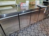 a stainless steel counter in a kitchen with a lot of dishes on it