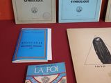 Plusieurs livres sont posés sur une table recouverte d'une nappe rouge.
