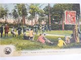 an old postcard of a group of people sitting in a field with horses