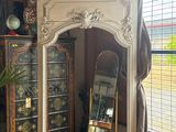 a mirror in the corner of a room next to a cabinet