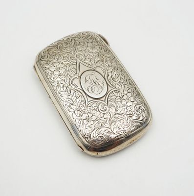 an antique silver cigarette case with a monogram on the front