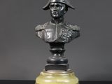 un buste en bronze représentant un homme portant un casque, posé sur une table