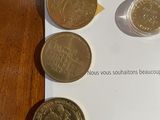 five different coins on a piece of paper on a table