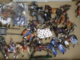 a box full of toy figurines of knights and horses