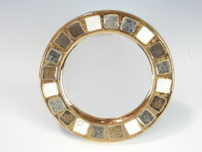 a gold plate with a mirror on it on a table