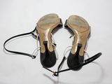 une paire de chaussures à talons hauts noires posées sur une surface blanche