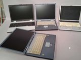 several laptops are lined up on a table in a row