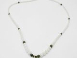 un collier blanc orné d'un pendentif représentant un Bouddha vert