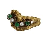 an image of a close up of a gold ring with emerald stones