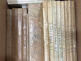many books in a box that are sitting on a table