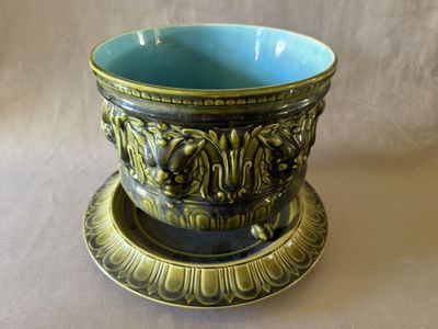 un bol bleu et vert posé sur une soucoupe