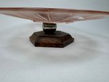 a glass bowl on a wooden stand on a white surface