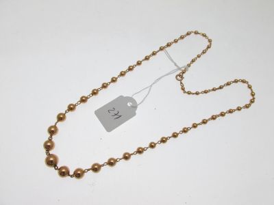 a close up of a gold necklace with a tag on it