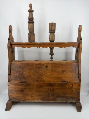an old wooden magazine rack with two candles on top of it