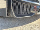 a close up of a car ' s grille with a reflection of a person on it