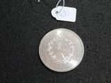 a silver coin on a black surface with a price tag on it